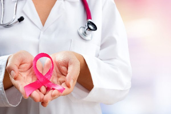 Cancer specialist in Secunderabad holding pink ribbon symbol for cancer awareness